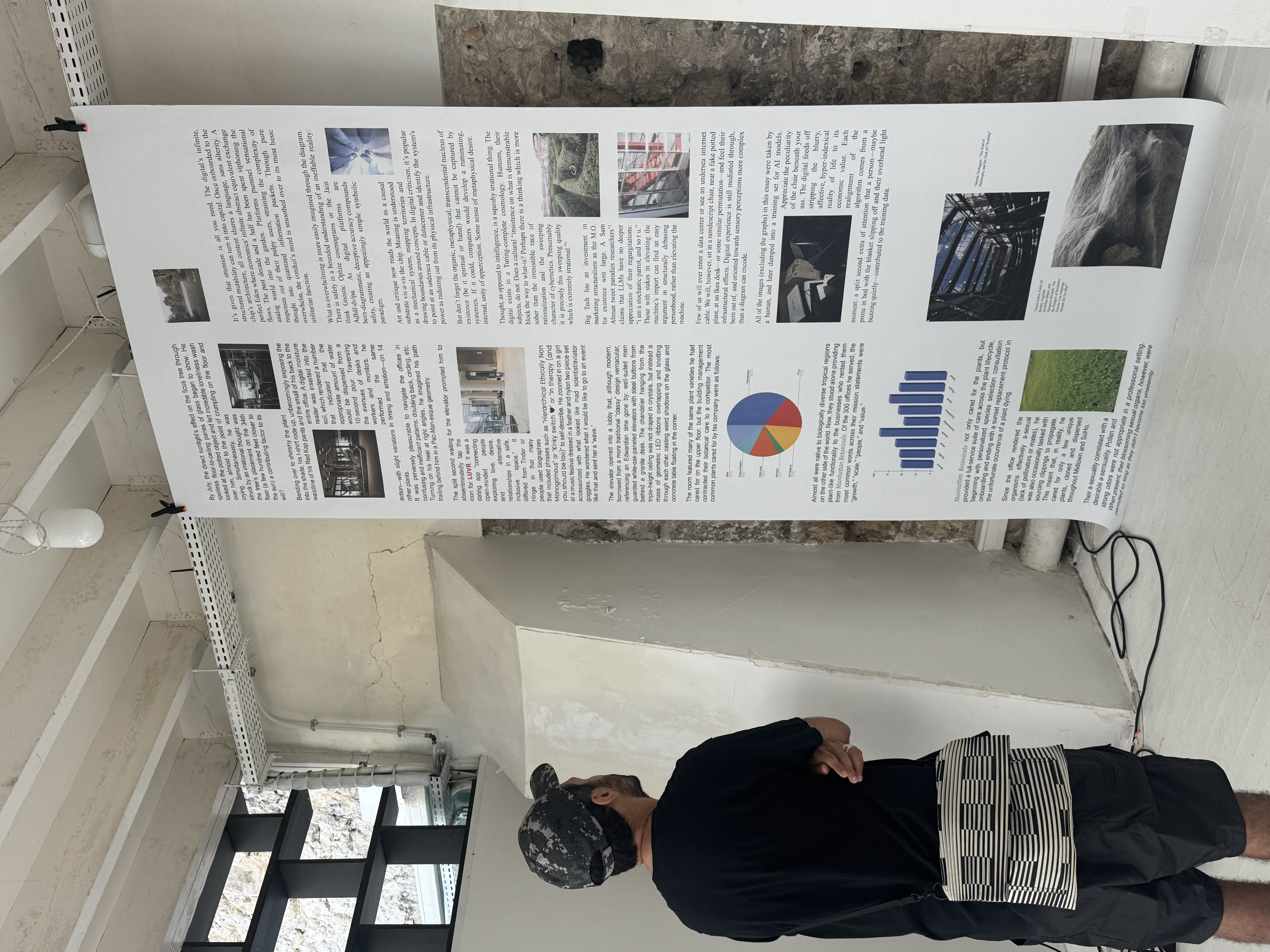Photo of a man standing reading a long scroll of text hanging from the ceiling