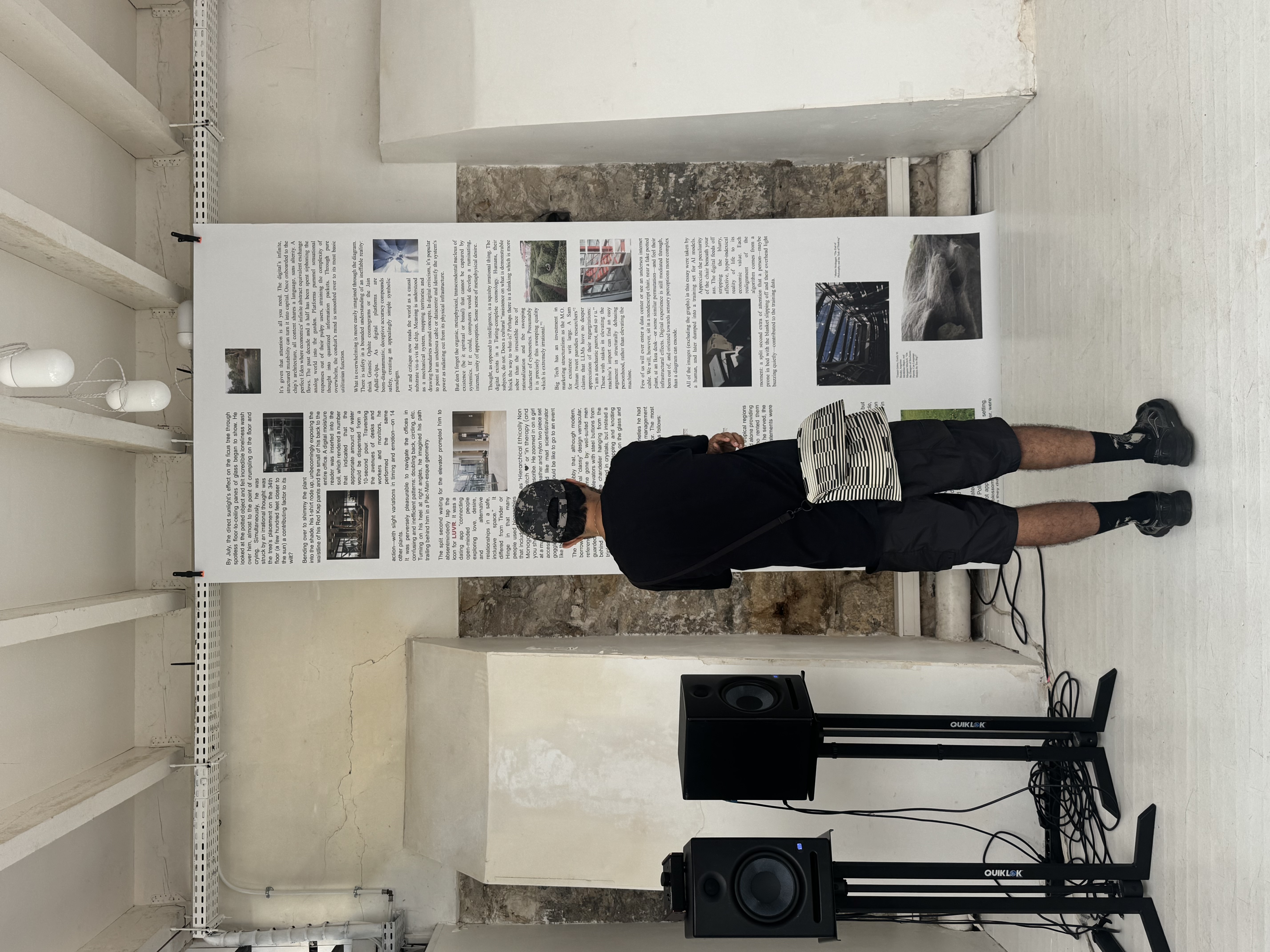 Photo of a man standing reading a long scroll of text hanging from the ceiling